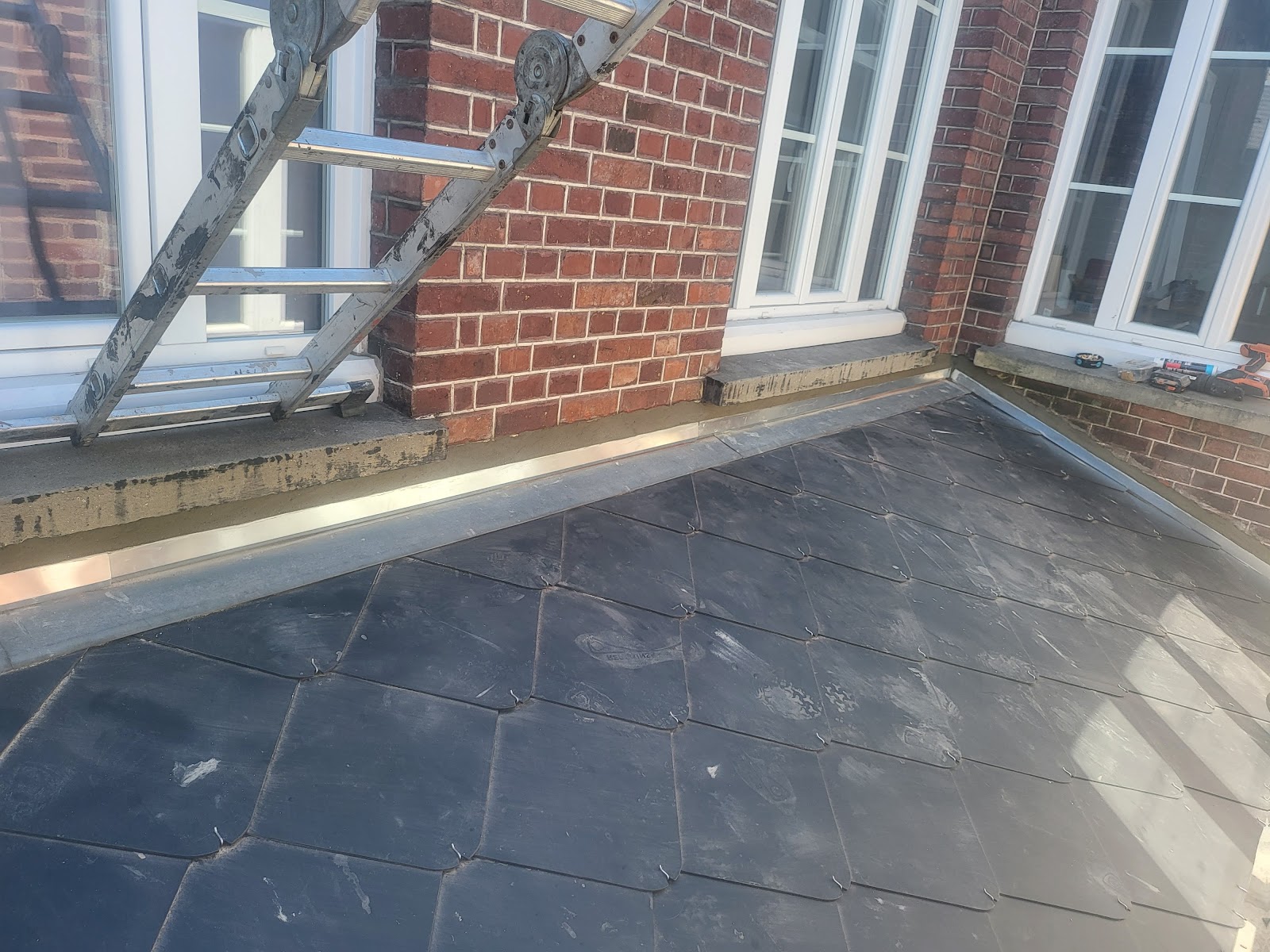 Étanchéité et finition en zinc sur une toiture terrasse en ardoise